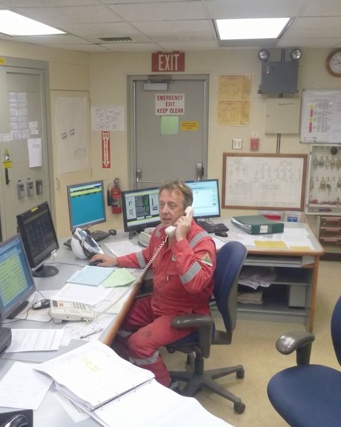Michael Sherriffs on the telephone at the control room panel of an offshore platform.